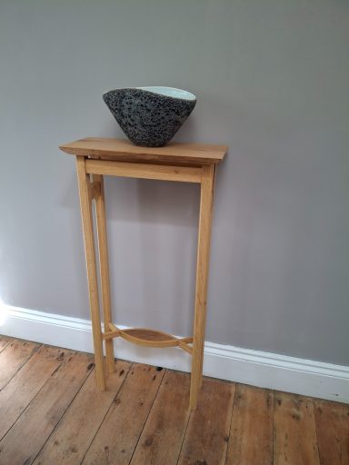 Slender occasional table with decorative stringer